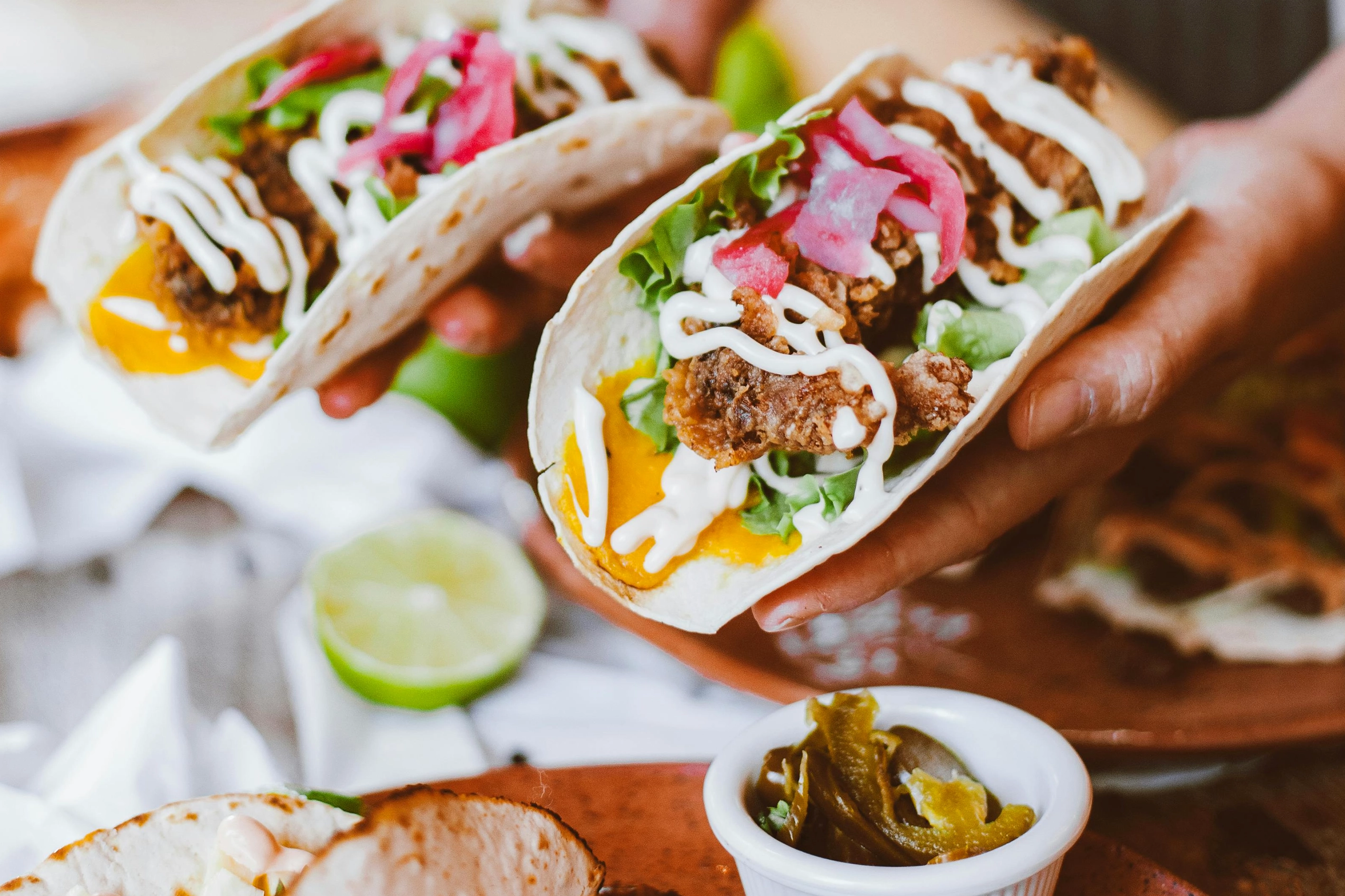 En närbild på tacos som en person håller fram
