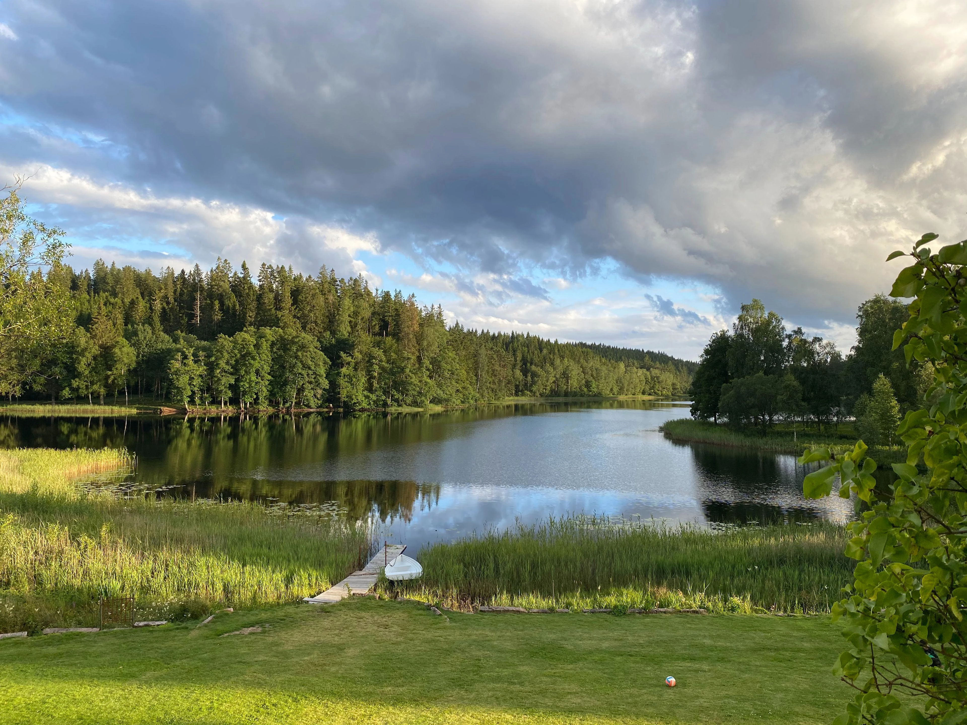 En sommarvy &ouml;ver en sj&ouml; med skog runt.